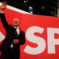The Social Democrats\' (SPD) candidate for chancellor, Olaf Scholz, waves on stage at SPD headquarters after early election result predictions were broadcast on TV in Berlin on Sunday. | AFP-JIJI