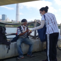 A Chilean missionary hands out goods to homeless people living by the Sumida River in Tokyo on Sept. 22. | ALEX K.T. MARTIN
