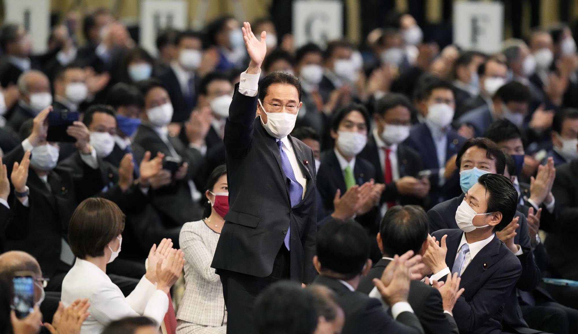 Former Foreign Minister Fumio Kishida waves after he was elected Liberal Democratic Party president on Wednesday in Tokyo. | KYODO