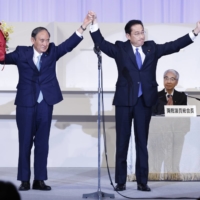 Fumio Kishida joins hands on stage with outgoing Prime Minister Yoshihide Suga after winning the ruling Liberal Democratic Party\'s leadership election on Wednesday in Tokyo.  | BLOOMBERG