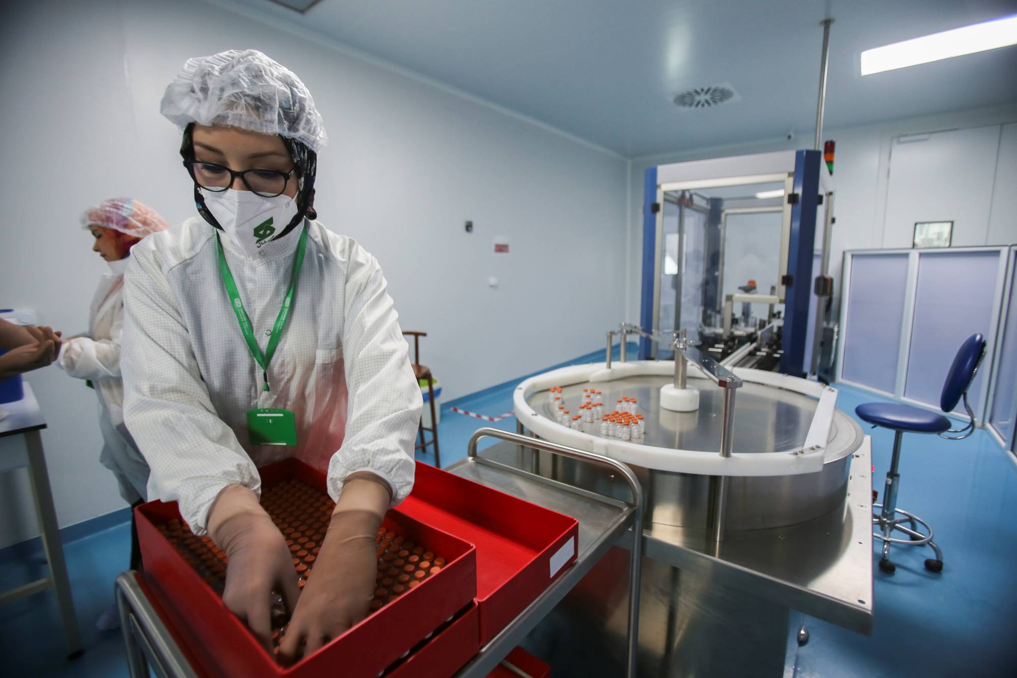 A lab technician arranges vials of Sinovac's COVID-19 vaccine at a lab in Constantine, Algeria, on Wednesday. | Reuters