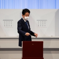 Former Prime Minister Shinzo Abe casts his vote in the Liberal Democratic Party\'s leadership election in Tokyo on Wednesday. | POOL / VIA REUTERS