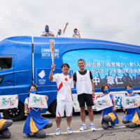 Torchbearer Akihito Tanaka (from the visually impaired soccer team) and the 2020 NTT trailer display messages of encouragement for torchbearers. | NTT