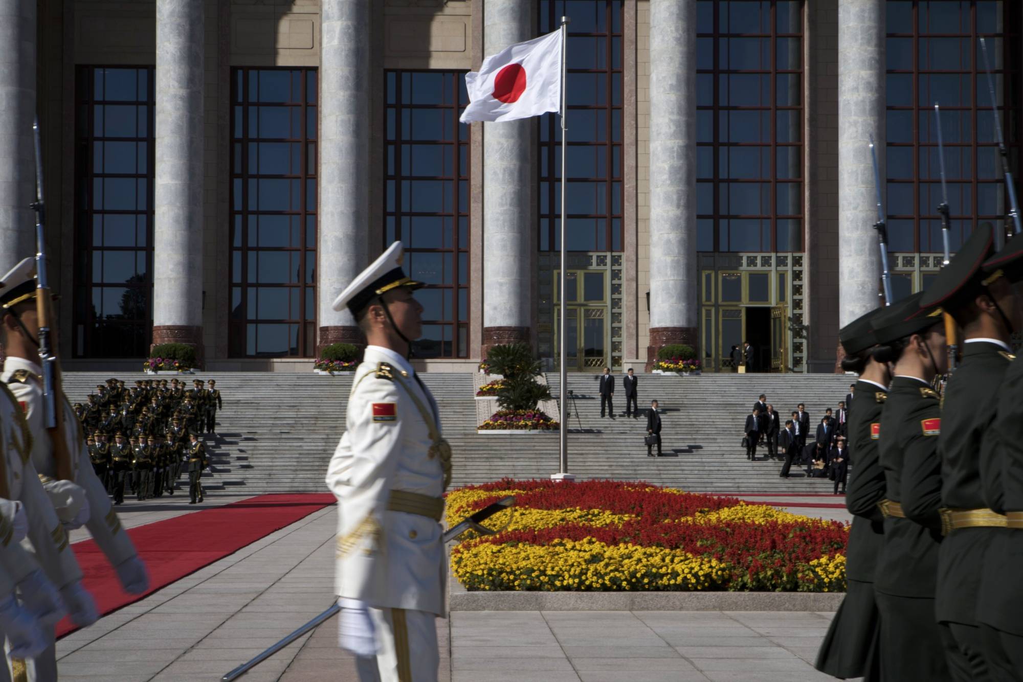 The Japanese flag is flown during a welcoming ceremony for Japanese Prime Minister Shinzo Abe at the Great Hall of the People in Beijing in October 2018. | BLOOMBERG