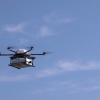 SoftBank Corp.\'s drone flies from the fishing port of Susami to a roadside station.  | COURTESY OF SOFTBANK CORP.
