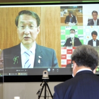 Tottori Gov. Shinji Hirai (left), head of the National Governors\' Association, speaks in an online meeting with Toshio Nakagawa (right), head of the Japan Medical Association, on Wednesday. | KYODO