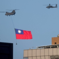 A Taiwan flag is carried above Taipei during a National Day rehearsal on Tuesday. | REUTERS