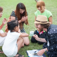 Brian Scott Peterson surprises a child with an instant photo at the Yarushakanebe Festival.  | TOMIO YAMAZAKI

