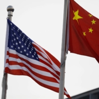 Chinese and U.S. flags flutter outside the building of an American company in Beijing. | REUTERS