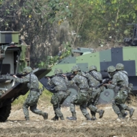 Taiwan special forces personnel walk behind an armored personnel carrier during an annual military drill in Taichung, Taiwan, in January 2017. | AFP-JIJI