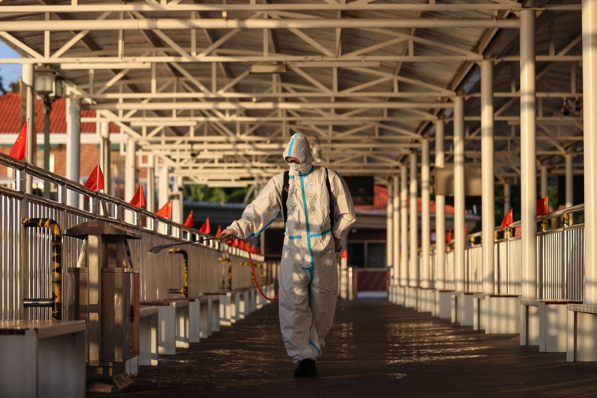 A staff member sprays disinfectant at Gulangyu Island in Xiamen, China's Fujian province, on Wednesday as the island prepares to reopen to tourists after being closed due to an outbreak of the coronavirus. | AFP-JIJI