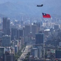 A Taiwan flag is carried by a Chinook helicopter during a rehearsal for the upcoming National Day celebration in Taipei on Thursday.  | REUTERS