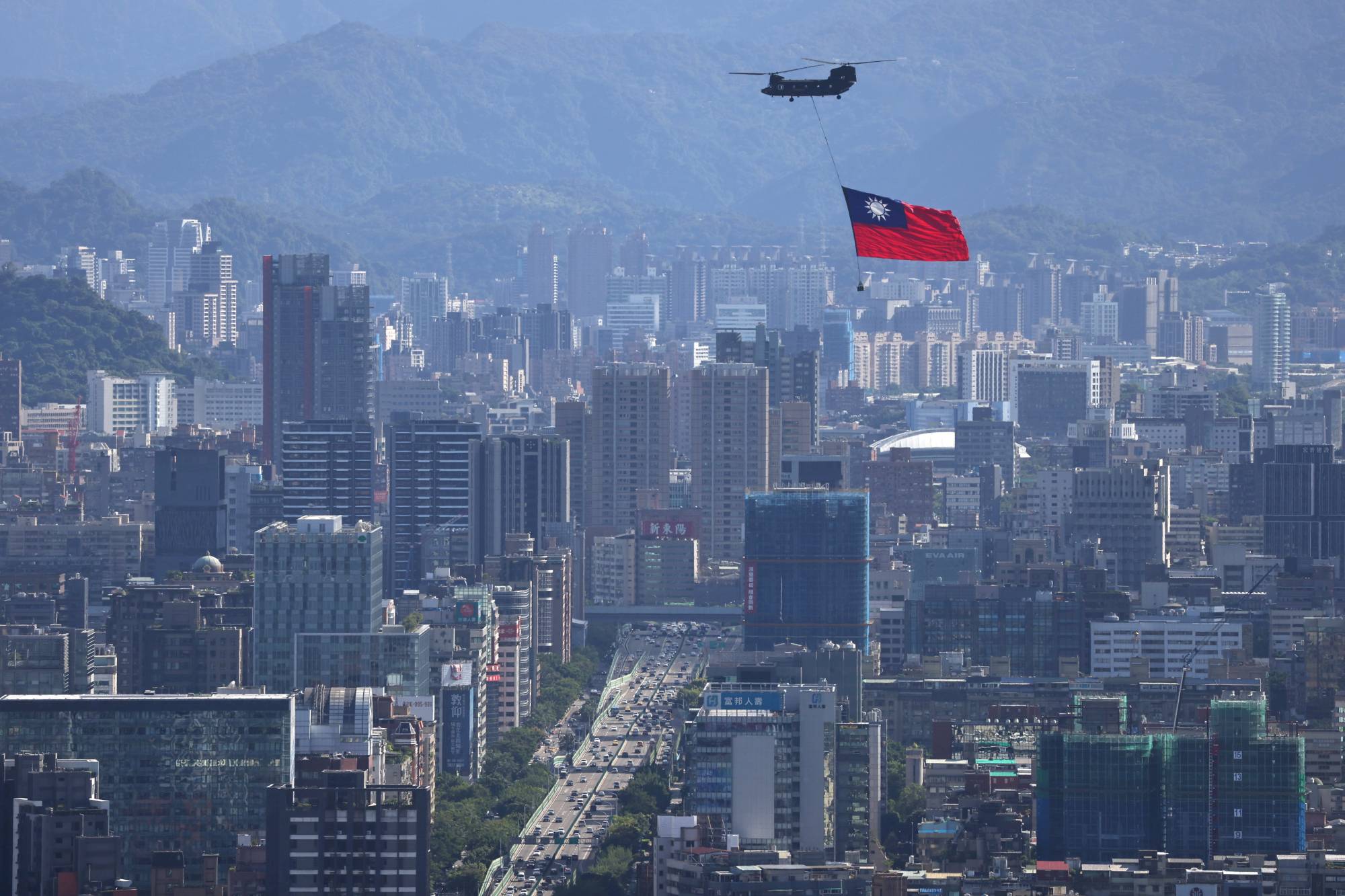 A Taiwan flag is carried by a Chinook helicopter during a rehearsal for the upcoming National Day celebration in Taipei on Thursday. | Reuters