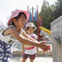 Children wash their hands at a park in Wakayama after water services were restored following a six day outage.  | KYODO 