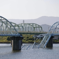 The collapse of an over 500-meter-long bridge that spans the Kinokawa river in Wakayama caused two water pipes to fall into the river on Sunday. | KYODO