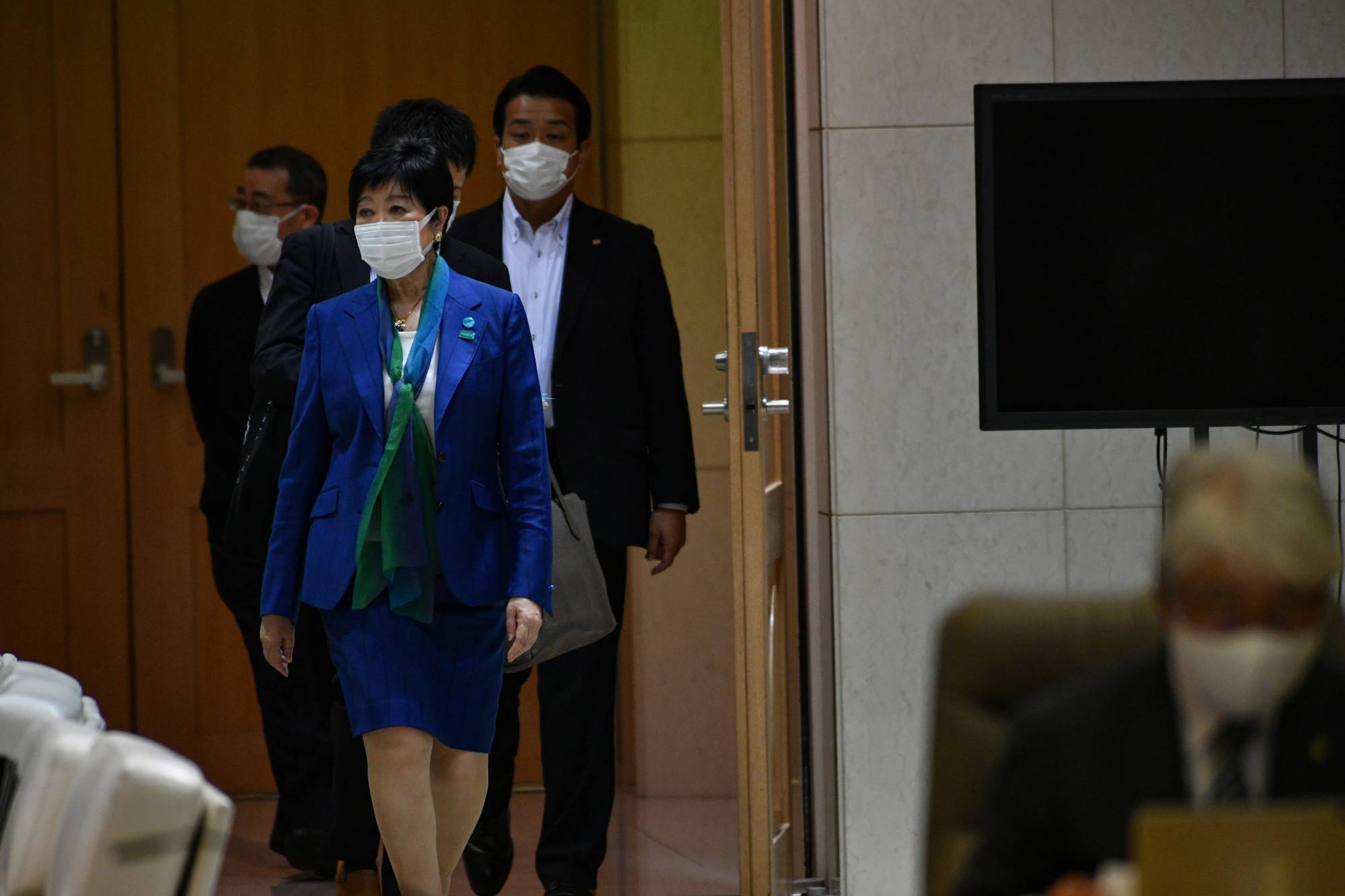 Tokyo Gov. Yuriko Koike heads into a meeting room in the Tokyo Metropolitan Government building Thursday ahead of a weekly coronavirus monitoring meeting. | Ryusei Takahashi 