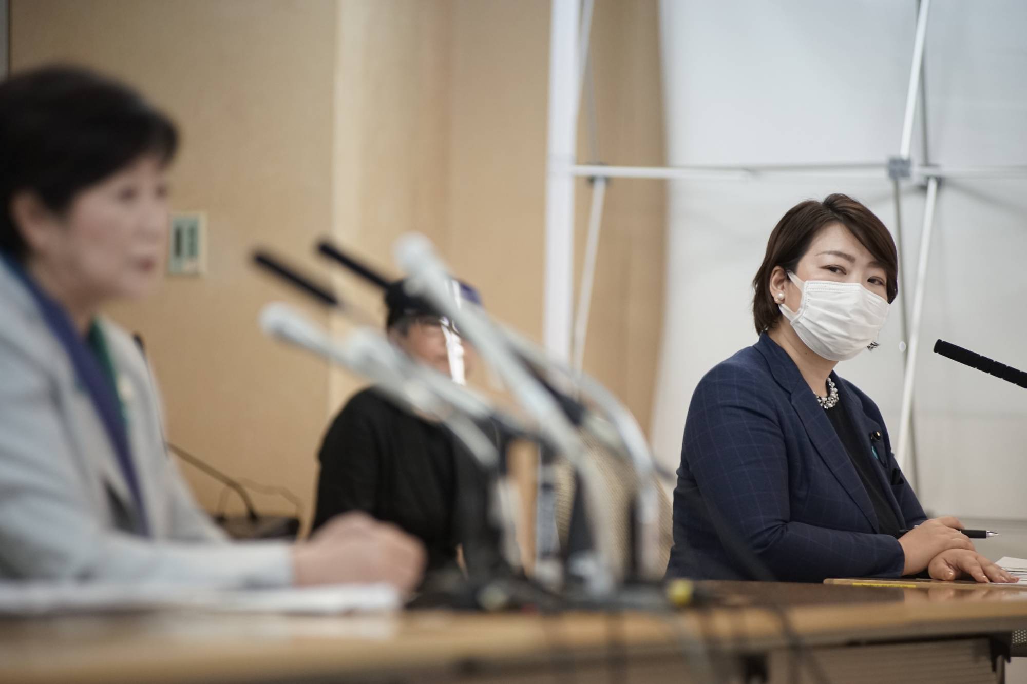 Chiharu Araki, leader of Tomin First, looks on as Tokyo Gov. Yuriko Koike announce her bid for re-election in June 2020 during the runup to the gubernatorial election. | Ryusei Takahashi 