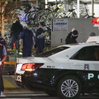 Police probe the scene of a fatal stabbing that left a 28-year-old woman dead Friday in Amagasaki, Hyogo Prefecture. | KYODO
