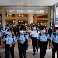 Police ask supporters to leave during the court hearing of Tong Ying-kit, the first person charged in Hong Kong under a new national security law imposed by Beijing. | REUTERS