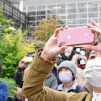A crowd of onlookers take pictures of Taro Kono as he makes an appearance on the campaign trail in a constituency at Aoba Ward, Yokohama, Kanagawa Prefecture, on Tuesday. | TOMOHIRO OSAKI
