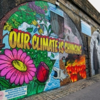 A climate change mural is seen on an archway near the location of the upcoming COP26 climate talks in Glasgow, Scotland, on Wednesday. | BLOOMBERG