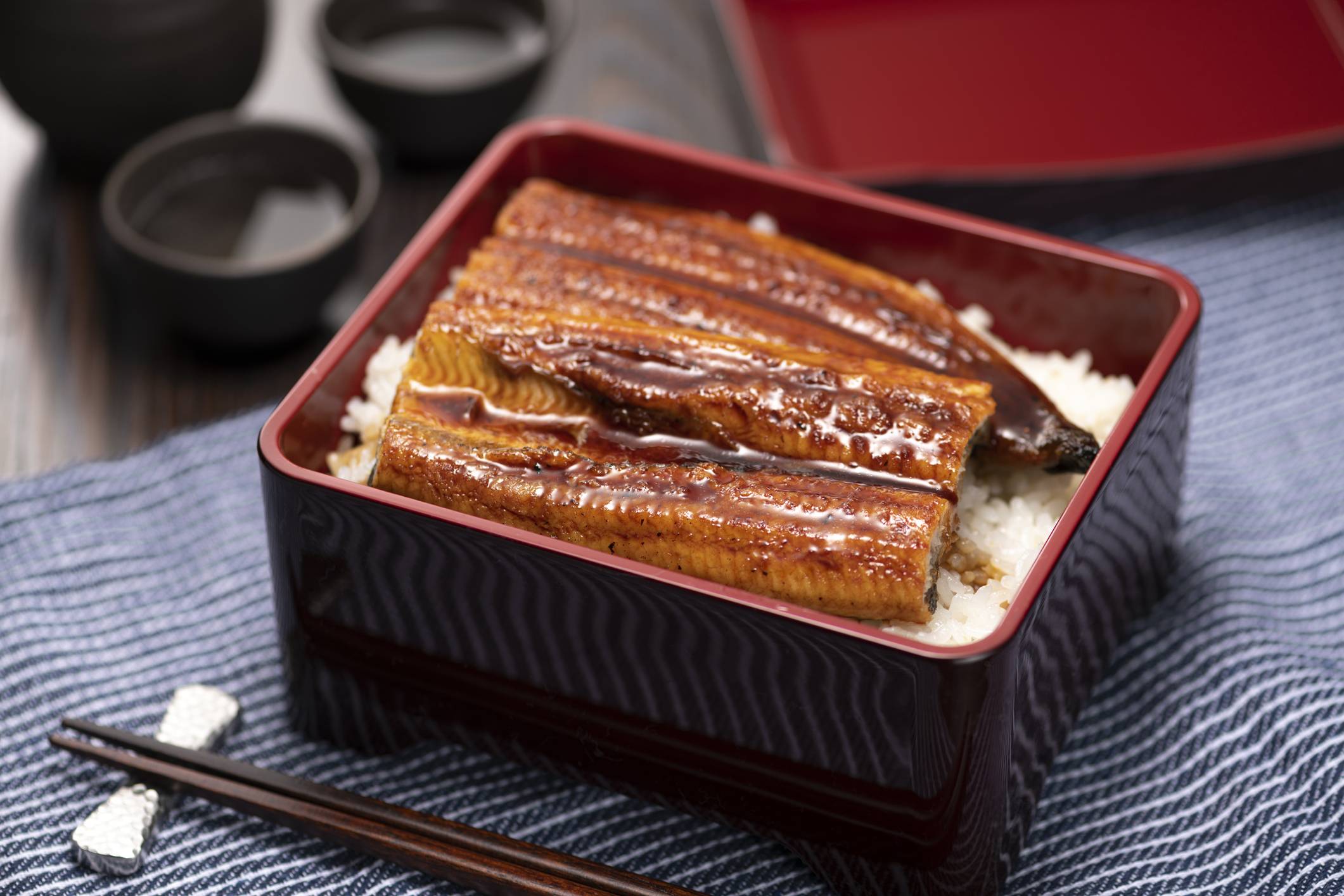A popular way to eat unagi eel is as unajū — grilled, slathered with tare sauce and served over rice in a lacquered box.  | GETTY IMAGES