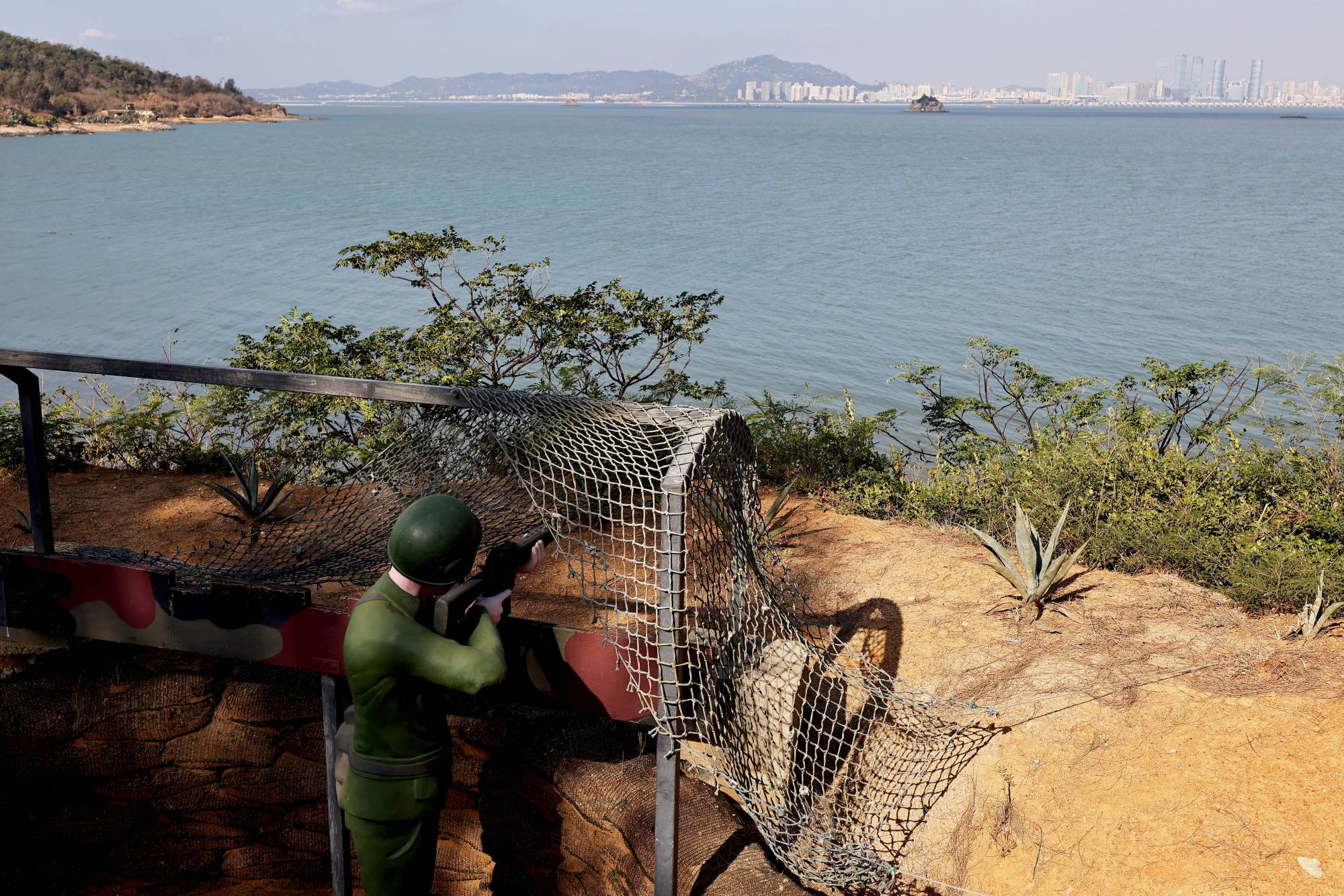 A mannequin dressed as a soldier aims toward China at the coastal line of Lieyu Township, Kinmen, Taiwan: the site of major fighting in 1958 at the height of the Cold War. | REUTERS
