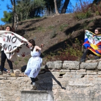 A security official tries to stop protesters holding the Tibetan flag and banner as they crash the flame lighting ceremony for the Beijing 2022 Winter Olympics at the Ancient Olympia archeological site, birthplace of the Olympics, in southern Greece on Oct. 18. | AFP-JIJI