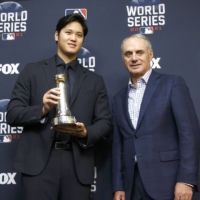 Shohei Ohtani (left) poses with MLB Commissioner Rob Manfred after receiving the Commissioner\'s Historic Achievement Award on Tuesday in Houston. | KYODO
