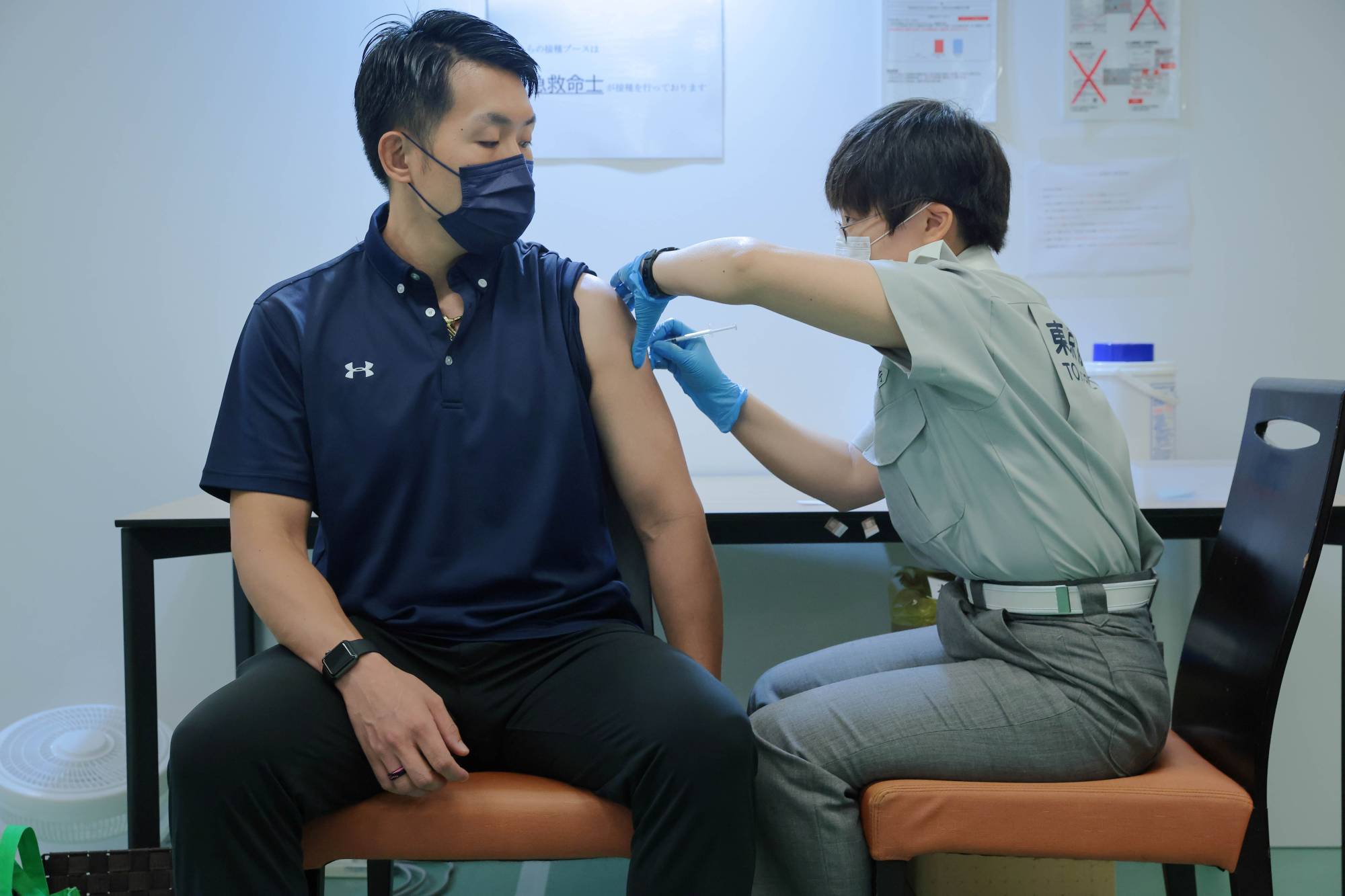 A man gets vaccinated in Tokyo in August.  | POOL / VIA REUTERS
