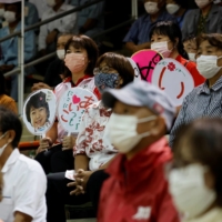 Supporters of Aiko Shimajiri, a candidate for the upcoming Lower House election backed by the ruling coalition Liberal Democratic Party and its junior partner Komeito, hold a rally in Uruma, Okinawa prefecture, on Monday. | REUTERS