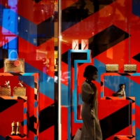 A woman walks past a luxury retail store in Tokyo\'s Ginza shopping district on Oct. 7. | REUTERS