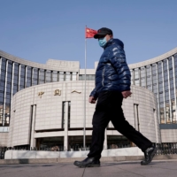 A man walks past the People\'s Bank of China in Beijing. A senior member of the Bank called cross-border brokerages \"illegal financial activities,” causing the stock of the companies behind them to plummet.  | REUTERS