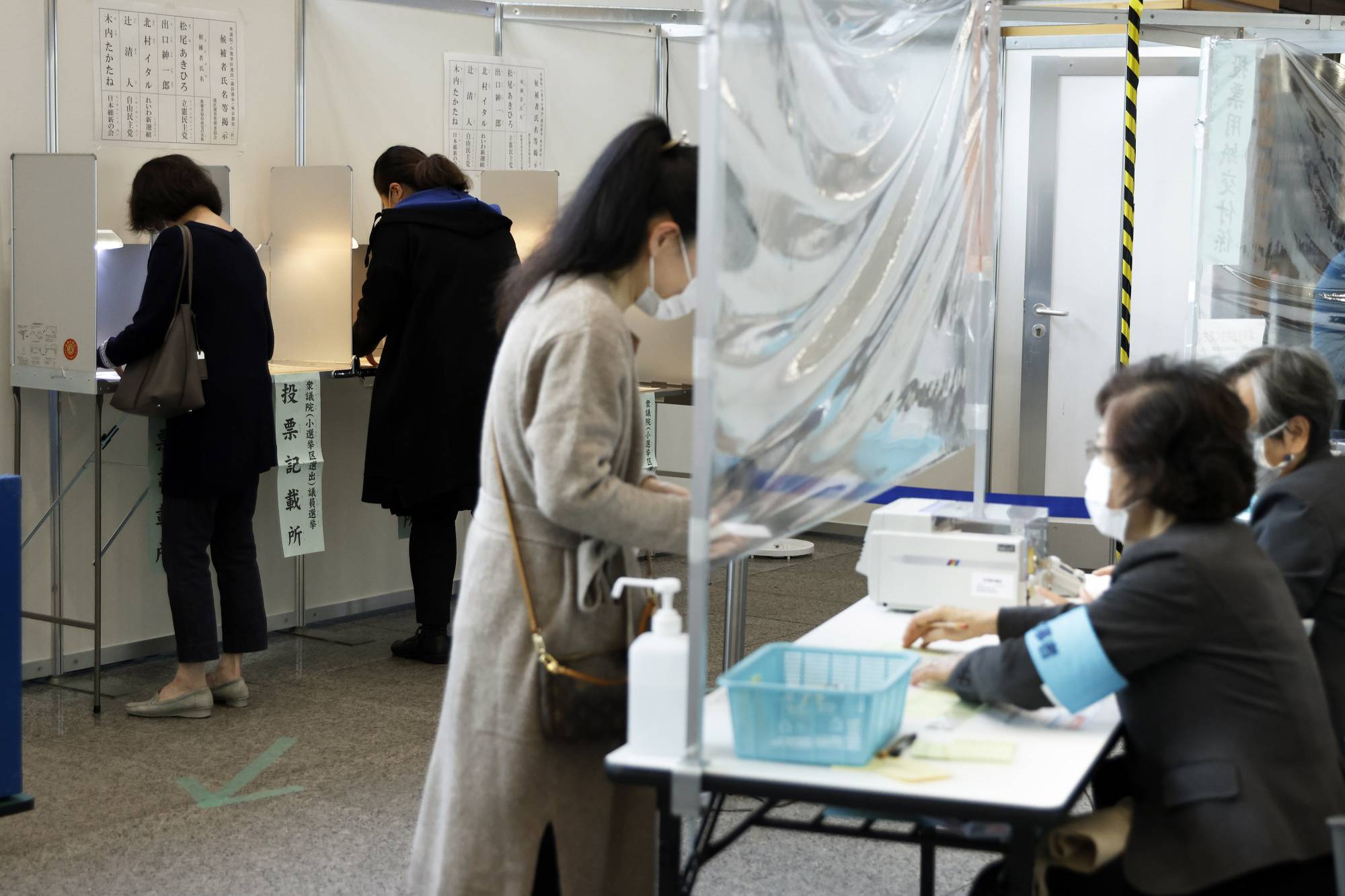 Voters cast ballots at an early voting location in Tokyo's Minato Ward on Thursday, ahead of Sunday's Lower House election. | BLOOMBERG