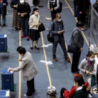 Voters queue up inside a polling station in Tokyo on Sunday. | AFP-JIJI