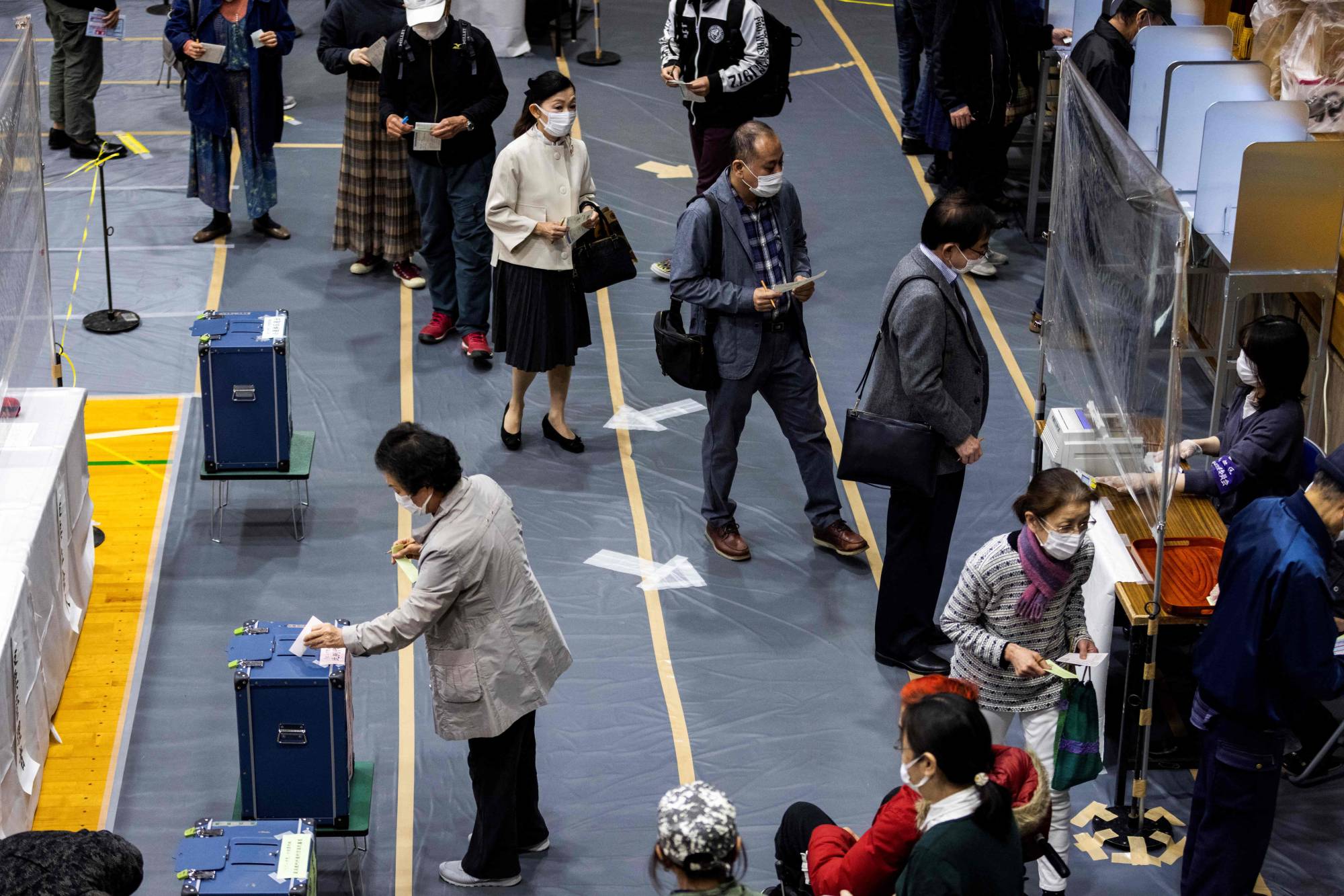 Voters queue up inside a polling station in Tokyo on Sunday. | AFP-JIJI