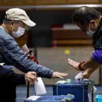 Voters cast their ballots in the Lower House election at a polling station in Tokyo on Sunday. | AFP-JIJI