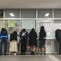 Voters fill in their ballots at a polling station in Tokyo\'s Shinjuku Ward on Sunday. | BLOOMBERG