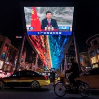 A screen displays a CCTV state media news broadcast showing Chinese President Xi Jinping addressing world leaders at the Group of 20 meeting in Rome via video link at a shopping mall in Beijing on Sunday. | REUTERS