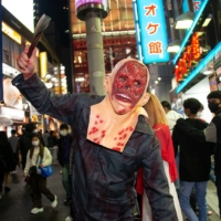 \"Sekiya,\" 27, poses on a shopping street in Shibuya on Halloween night. As for the election? \"I have zero interest,\" Sekiya says, adding that he never votes. \"There\'s really no benefit in voting. Nothing changes.\" | ROB GILHOOLY