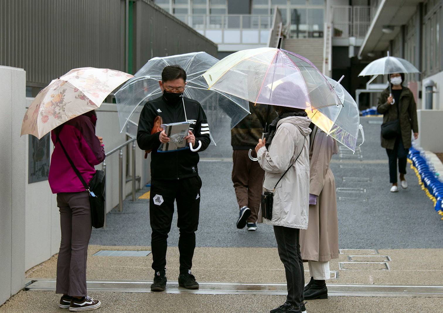 A man completes an exit survey after voting at a polling station as Japan's general election got underway in Setagaya Ward on Sunday. According to ward official Yoshinari Ando, morning voting numbers at the station had been good compared with previous years, adding they had tailed off significantly in the afternoon as the rain started to fall. Early voting numbers would seem to suggest a 'decent turnout,' he says, adding that the number of young voters — frequently low among Japan's voting public — had also been reasonably favorable, likely influenced by the polling station's proximity to youth culture capital Shimokitazawa. | ROB GILHOOLY