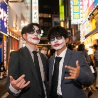 Eito Hoshi (right) and Kodai Mori, both 18, pose for a photo on Sunday. With Japan\'s voting age having been lowered to 18 five years ago, Mori had decided to visit his local polling station to post a ballot for the first time. \"But, then there was this: my first time to experience Halloween,\" he says, adding he borrowed one of his dad’s suits as a sort of comment on salaried workers. \"I am interested in politics and economics, so I wanted to make use of my right to vote. But it’s difficult to relate to Japanese politicians, who are all older, and don\'t have a clue what younger people are thinking. Politics isn\'t really presented as something for young people like us. It\'s the older people who vote, and in the end they are the ones who stand most to gain. I want them to listen to the young people, to give us a say. They could start by allowing online voting. You can manage your finances online, right? I think if we had online voting, you\'d see a massive increase in young voters. But perhaps that\'s not what they want.\" | ROB GILHOOLY