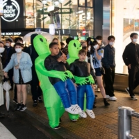Sidney Smallbone and Michelangelo Damato, both 12, are \"abducted\" by aliens during Halloween festivities in Shibuya on Sunday. A small foreign contingent was among the thousands who flocked to Shibuya to celebrate the imported holiday. | ROB GILHOOLY