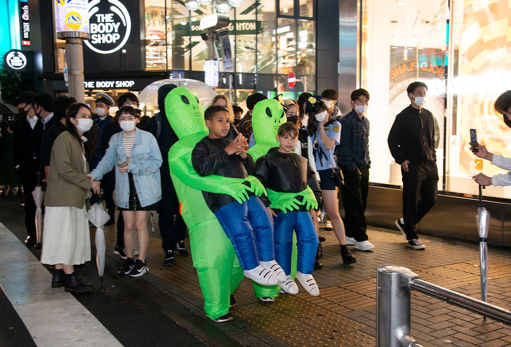 Sidney Smallbone and Michelangelo Damato, both 12, are 'abducted' by aliens during Halloween festivities in Shibuya on Sunday. A small foreign contingent was among the thousands who flocked to Shibuya to celebrate the imported holiday. | ROB GILHOOLY