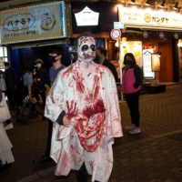 A reveler dressed up in zombie attire lets it all hang out on Sunday. | ROB GILHOOLY