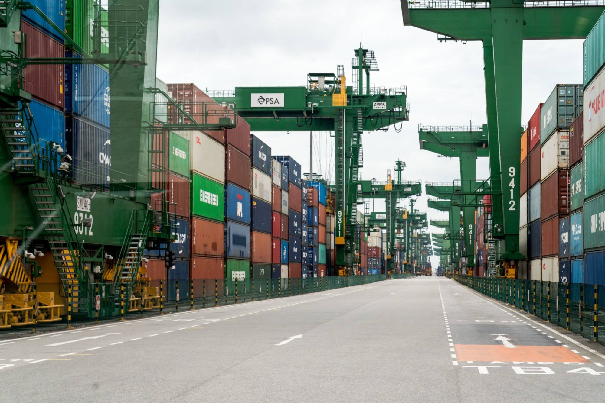 Containers are stacked next to gantry cranes at the Port of Singapore in Singapore. The city-state is a party to the Regional Comprehensive Economic Partnership, which Australia has said will take effect on Jan. 1. | BLOOMBERG