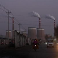 Commuters pass a coal-fired power station in Datong, in China\'s northern Shanxi province, on Wednesday. | AFP-JIJI