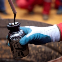 A worker collects a crude oil sample at an oil well in Morichal, Venezuela. | REUTERS 