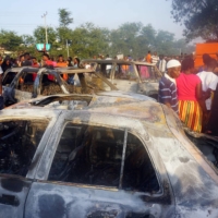 People look on at burnt cars in the aftermath of a fuel tanker explosion in Freetown on Saturday. | AFP-JIJI