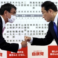 Prime Minister Fumio Kishida (right) fist bumps with former Foreign Minister Taro Kono after the general election at the LDP party’s headquarters in Tokyo on Oct. 31. Pool / via REUTERS
 | POOL / VIA REUTERS
